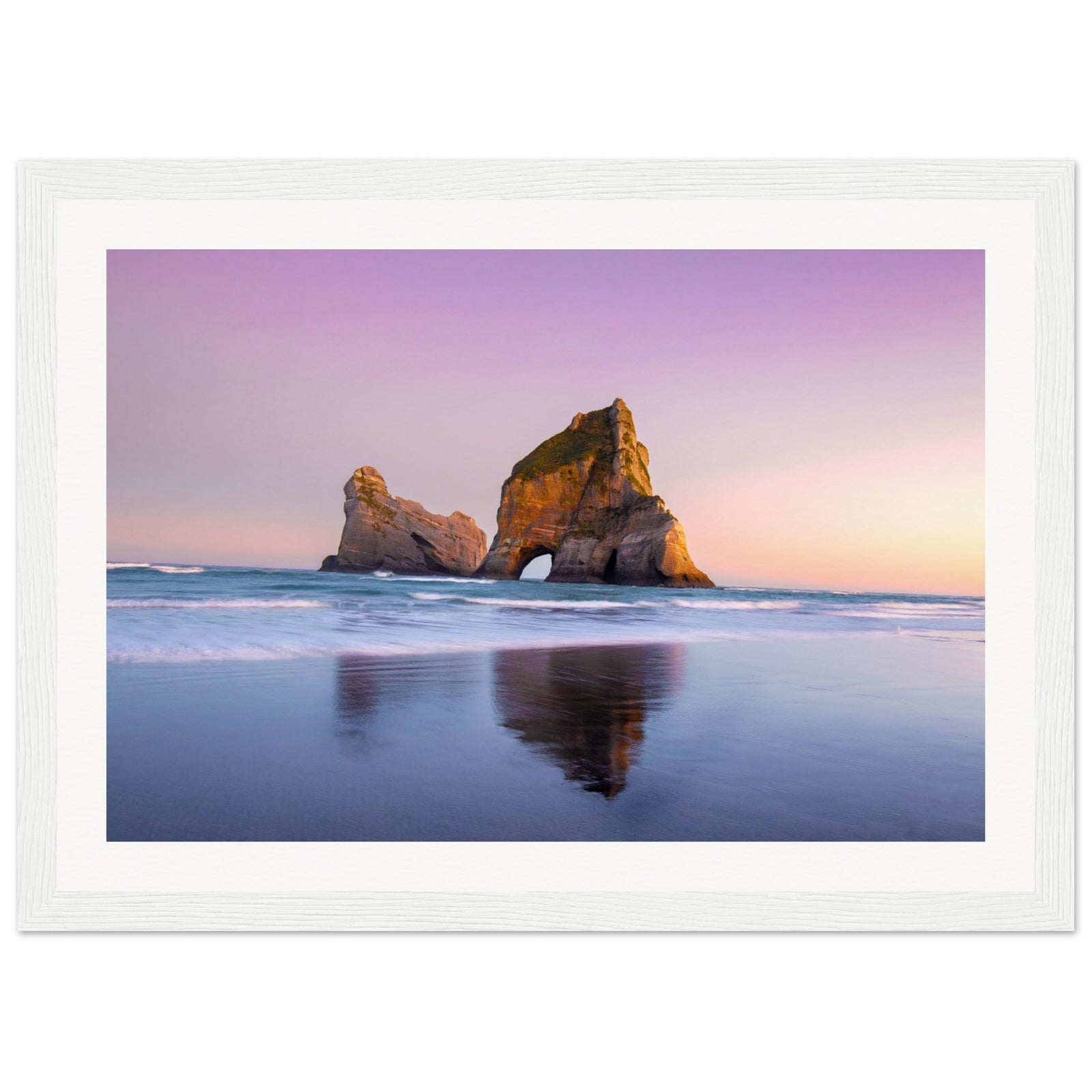 Vertical beach image capturing sea arch and sunset light.