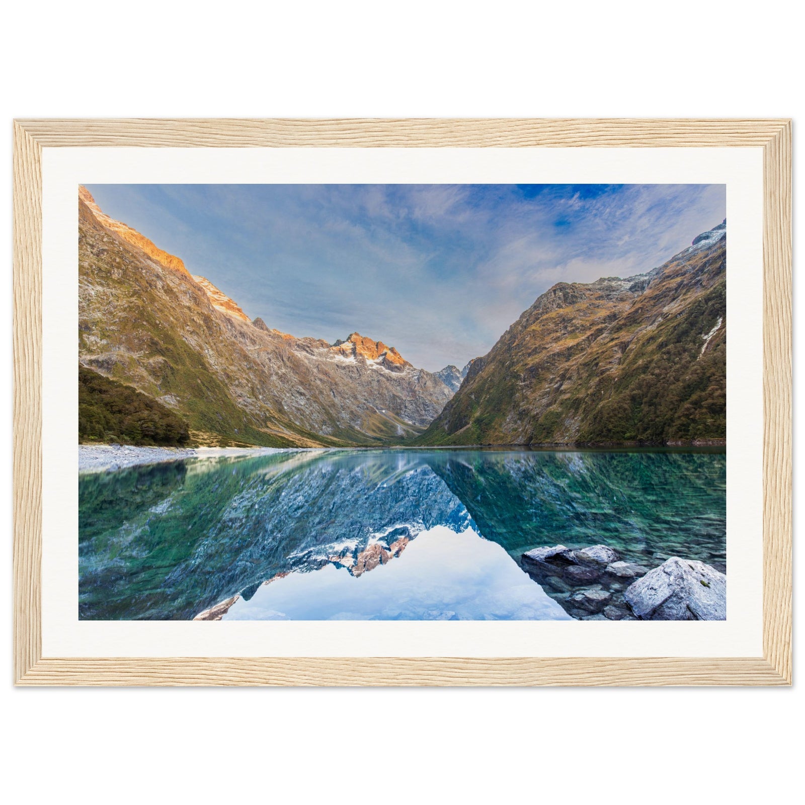 Framed portrait of a calm lake with mountains and a blue dot accent.