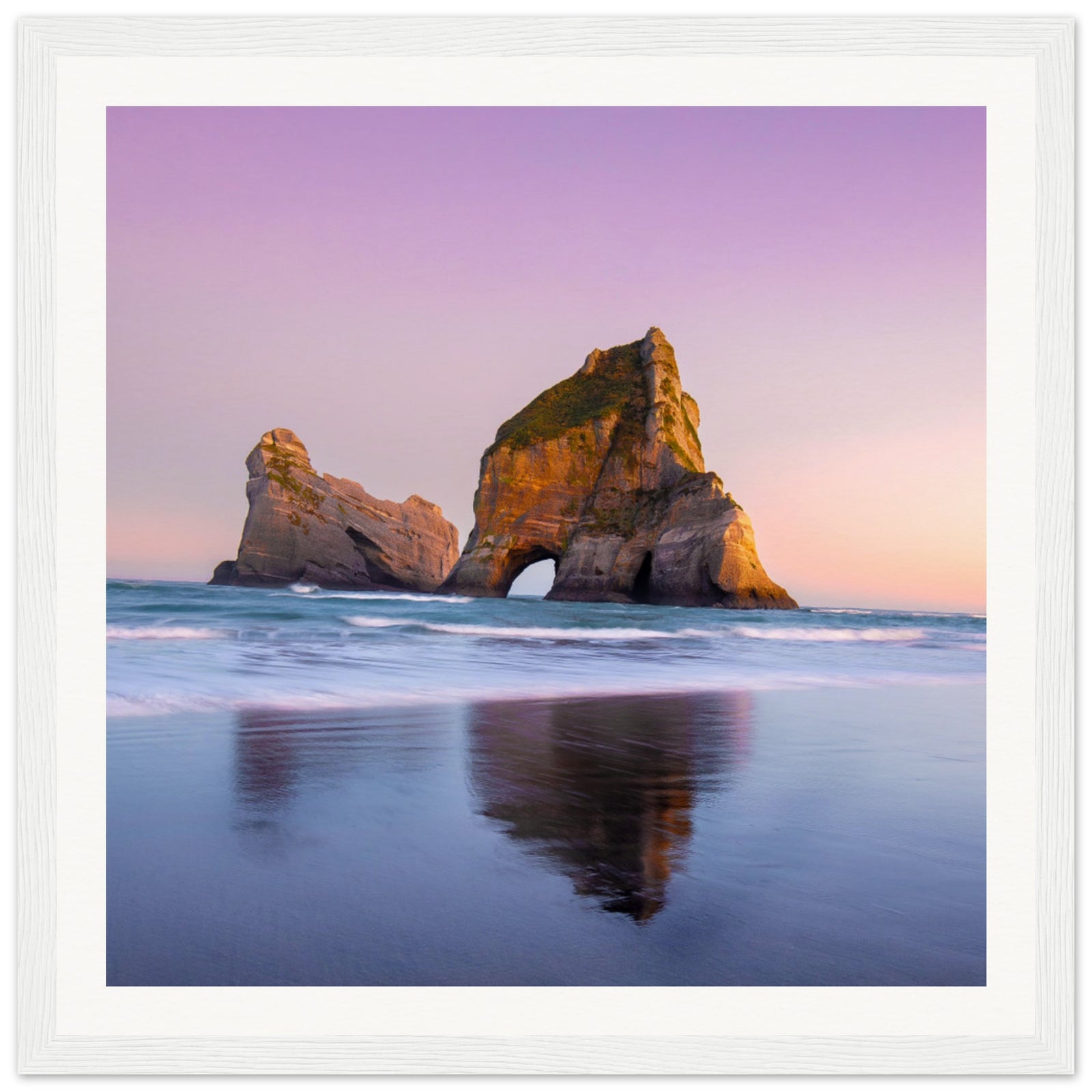 Framed wall art showing sea stack at dusk with gentle surf.