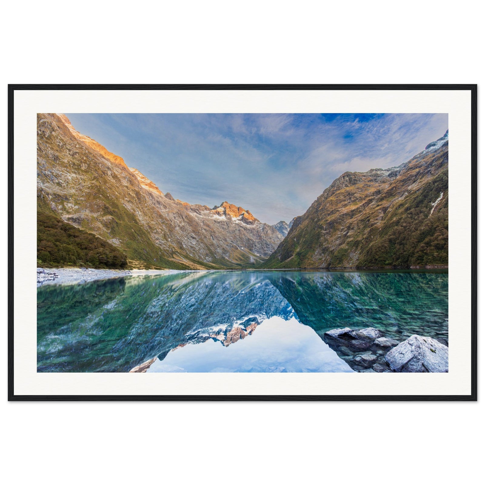 Portrait format of golden mountain ridge and still lake.