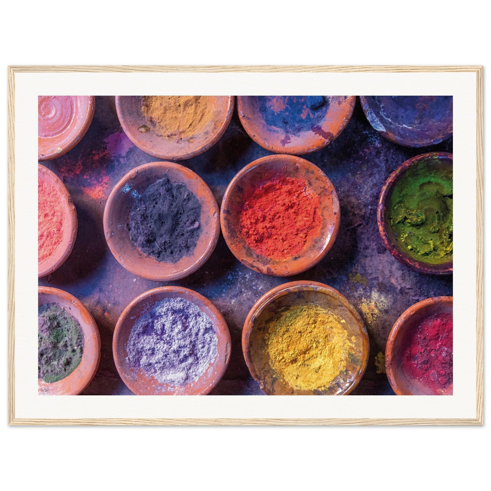 Terracotta bowls filled with colorful powders in a bright wall print.