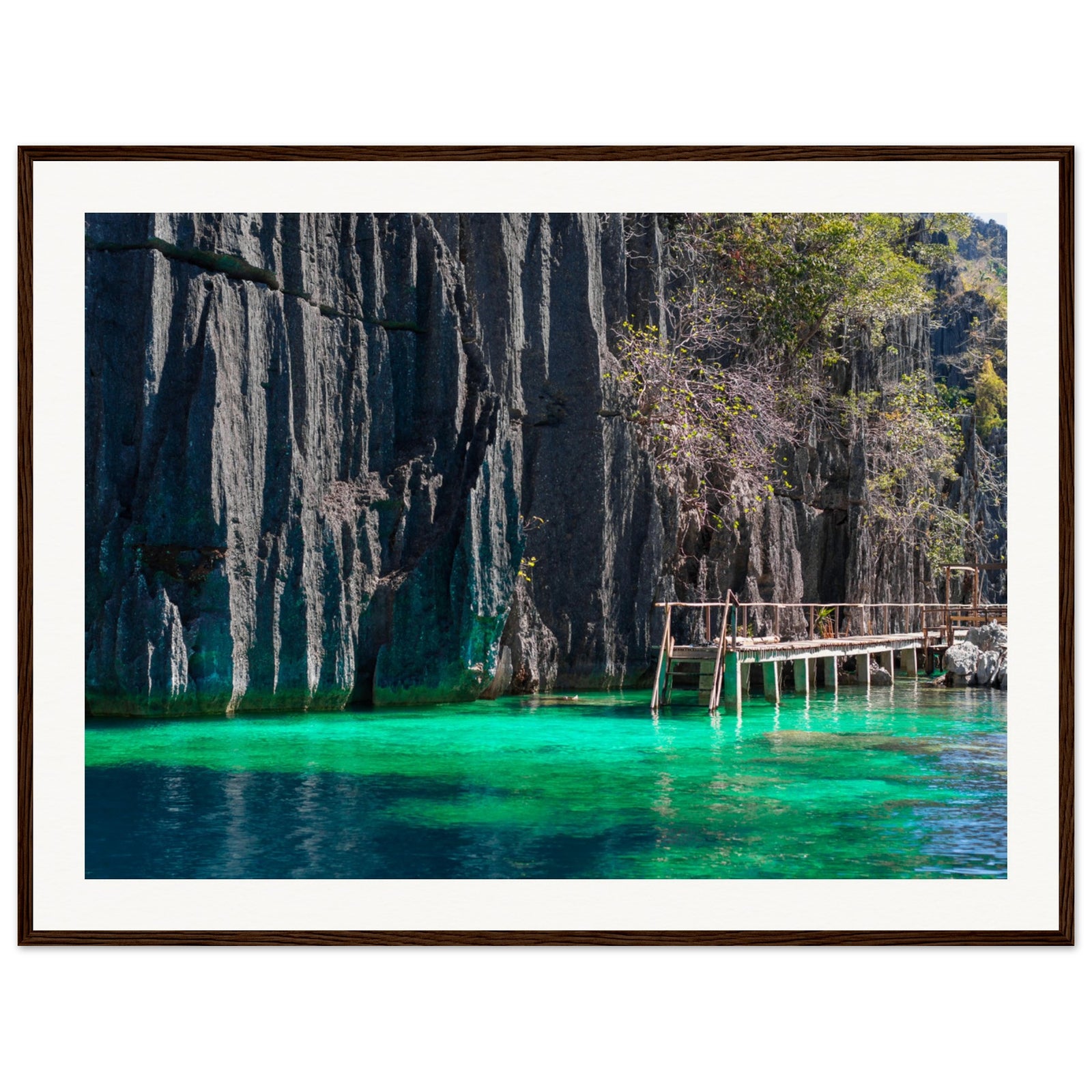 Framed portrait of rugged cliffside and serene emerald water.