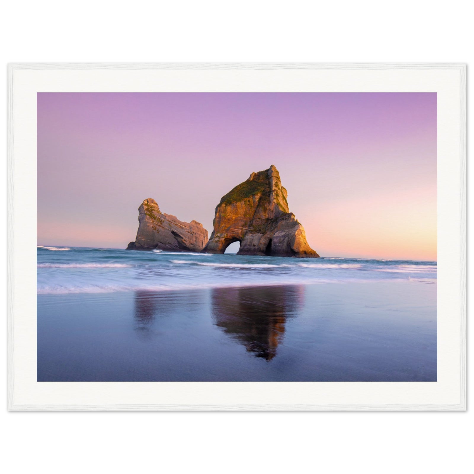 Pastel-toned ocean view with sea arch and soft reflections.