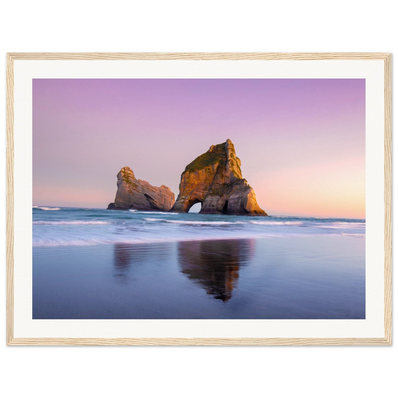 Dusk beach scene with reflective wet sand and sea stack.