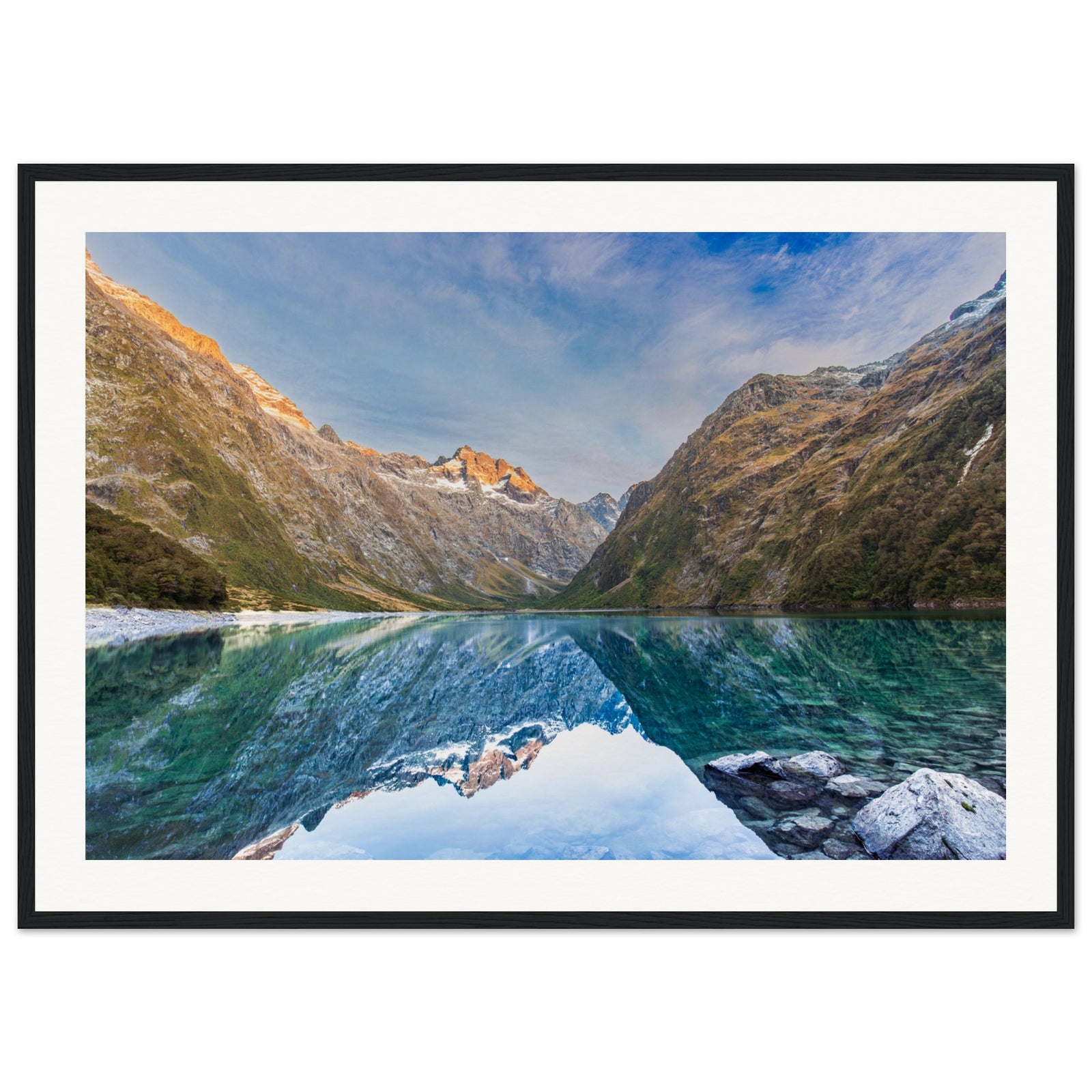 Landscape portrait featuring crystal lake and sunlit mountain.