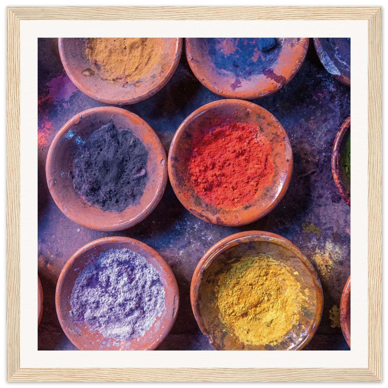Rustic pottery bowls holding vivid, dry powdered colors.