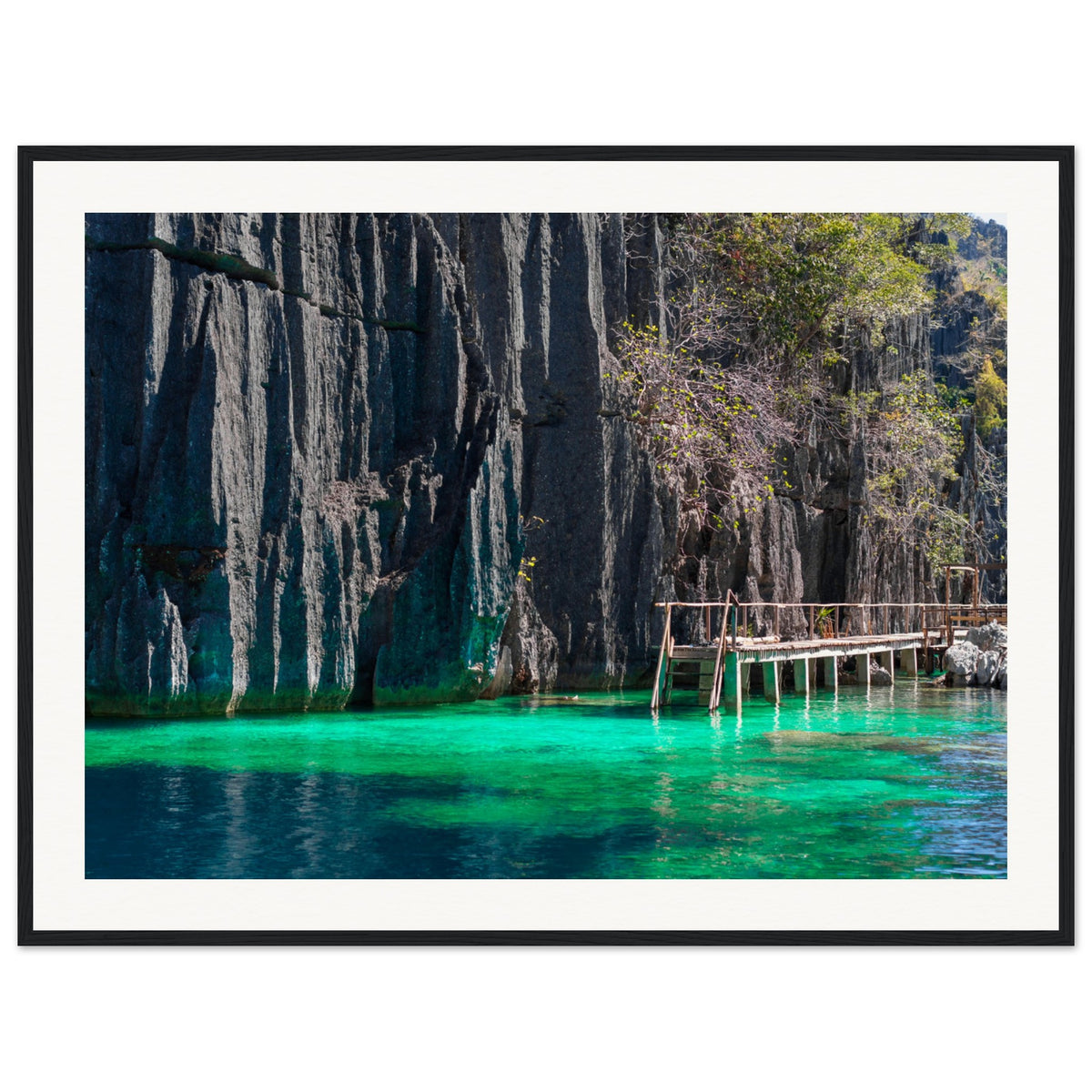 Portrait-style wall art of a tropical inlet with dramatic cliffs.

