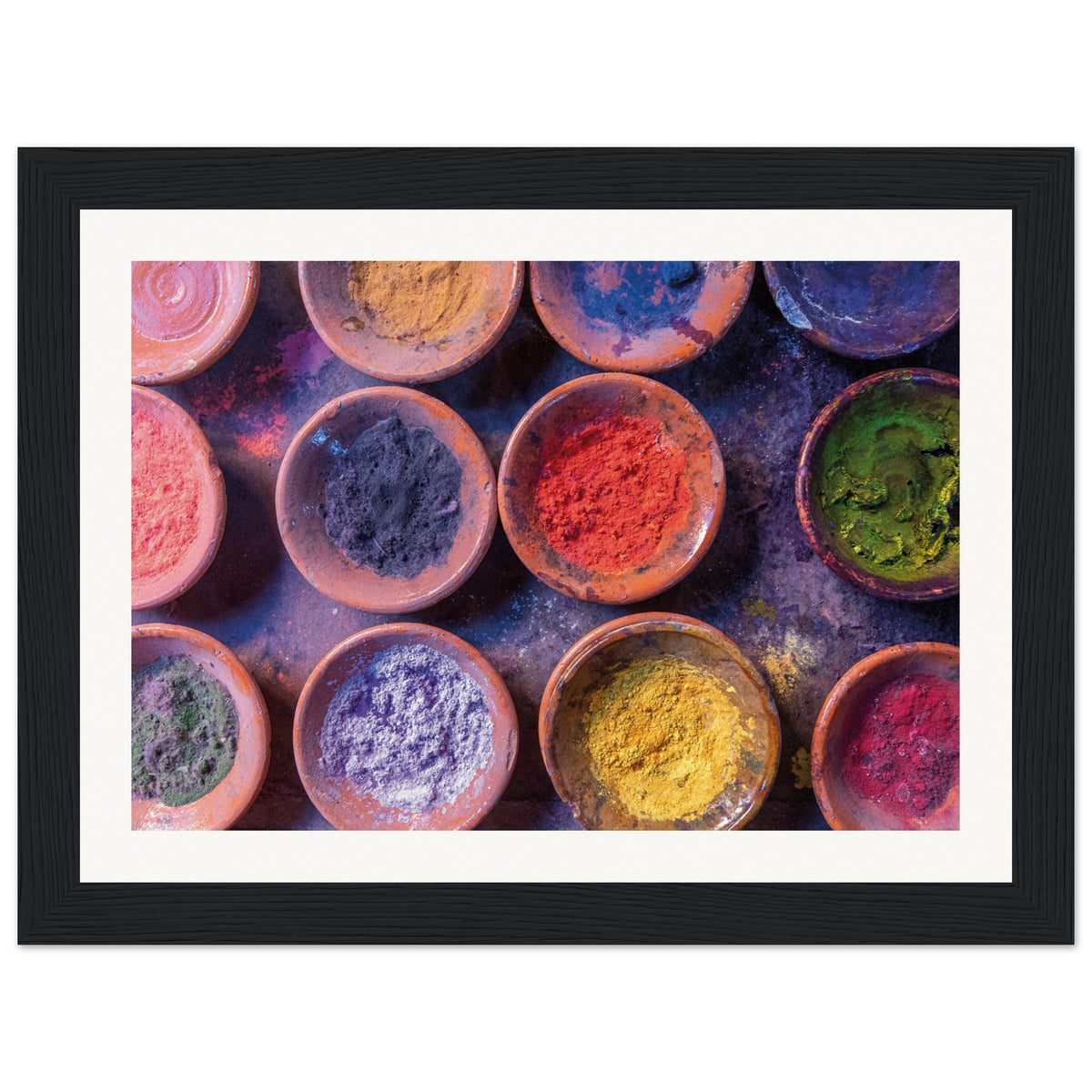 Framed image showing festive colored powders in round containers.

