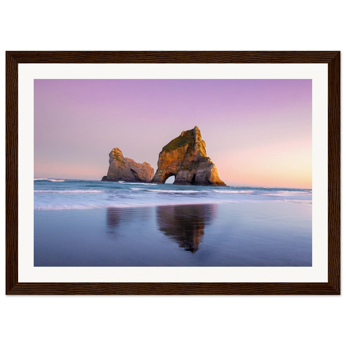 Seascape portrait showing gentle surf and island rock arch.

