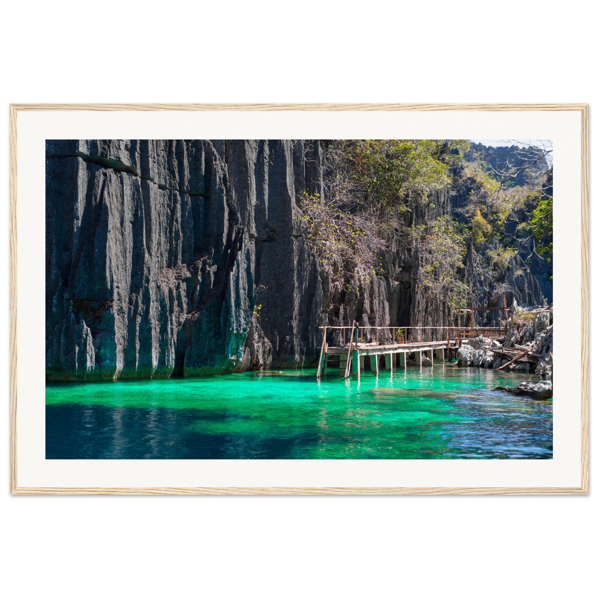 Portrait of island cliffs and clear blue-green water under sunlight.

