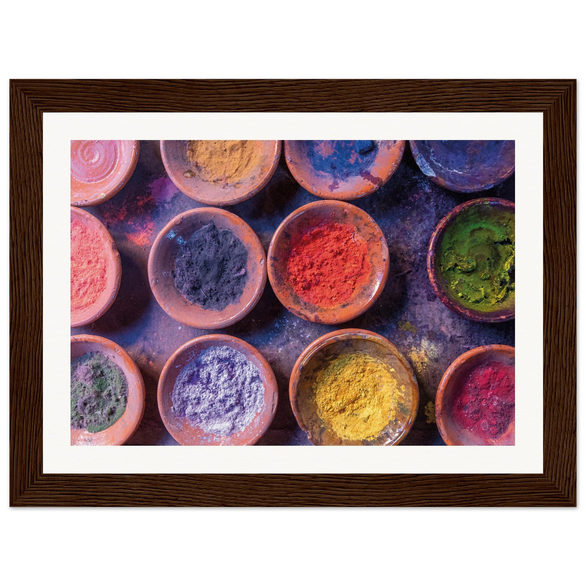Aerial view of rich, pigmented powders in pottery bowls.

