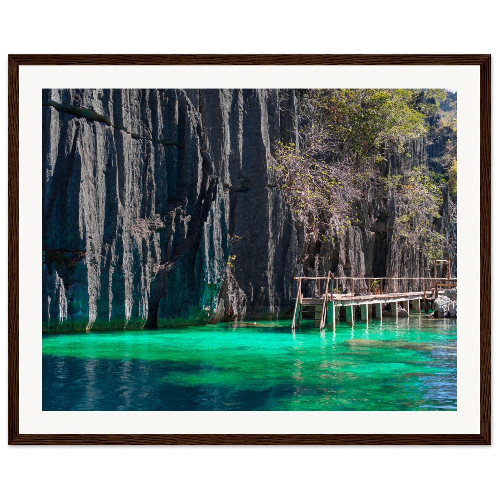 Portrait view of cliff shadows over luminous lagoon water.

