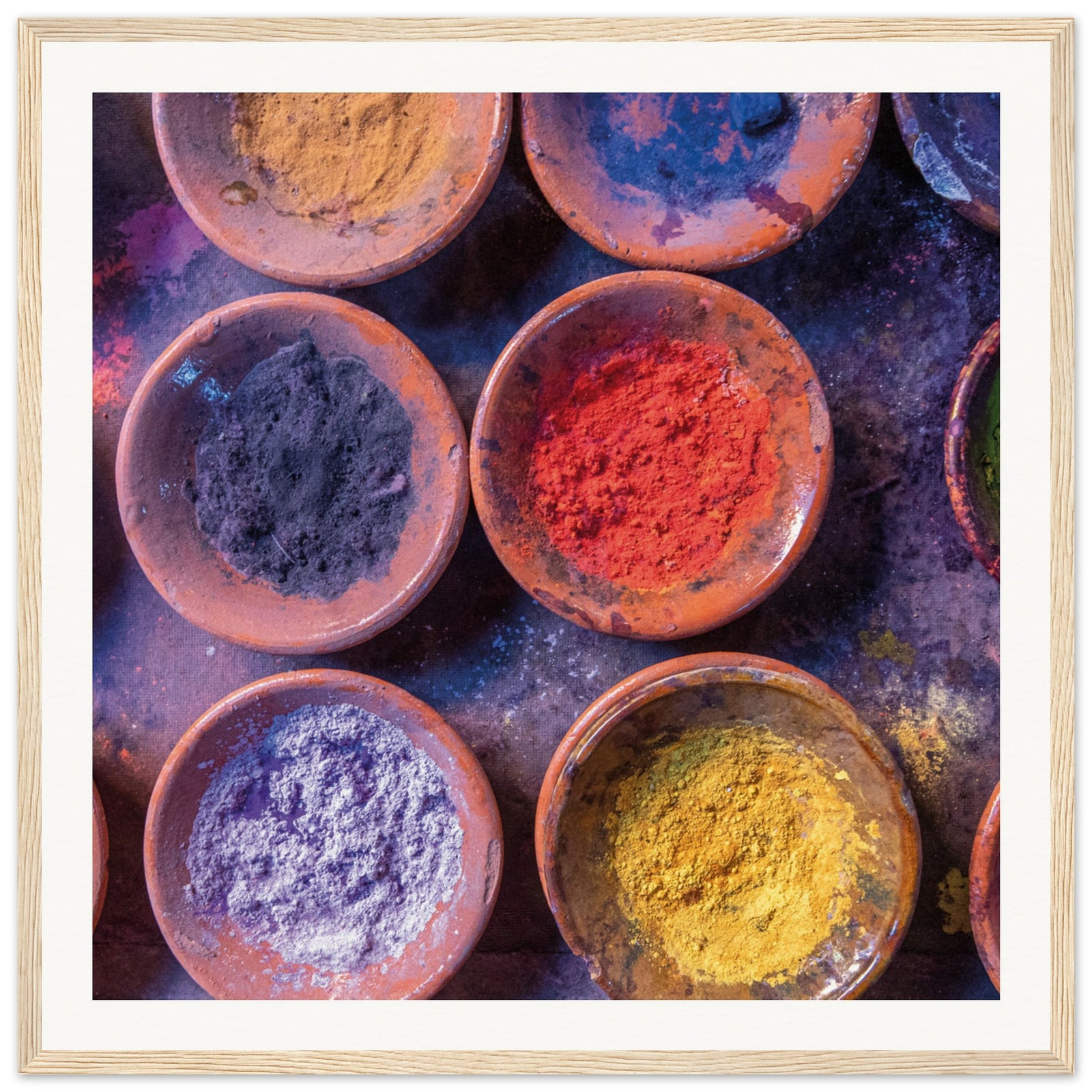 Decorative image of powdered pigments arranged in terracotta plates.

