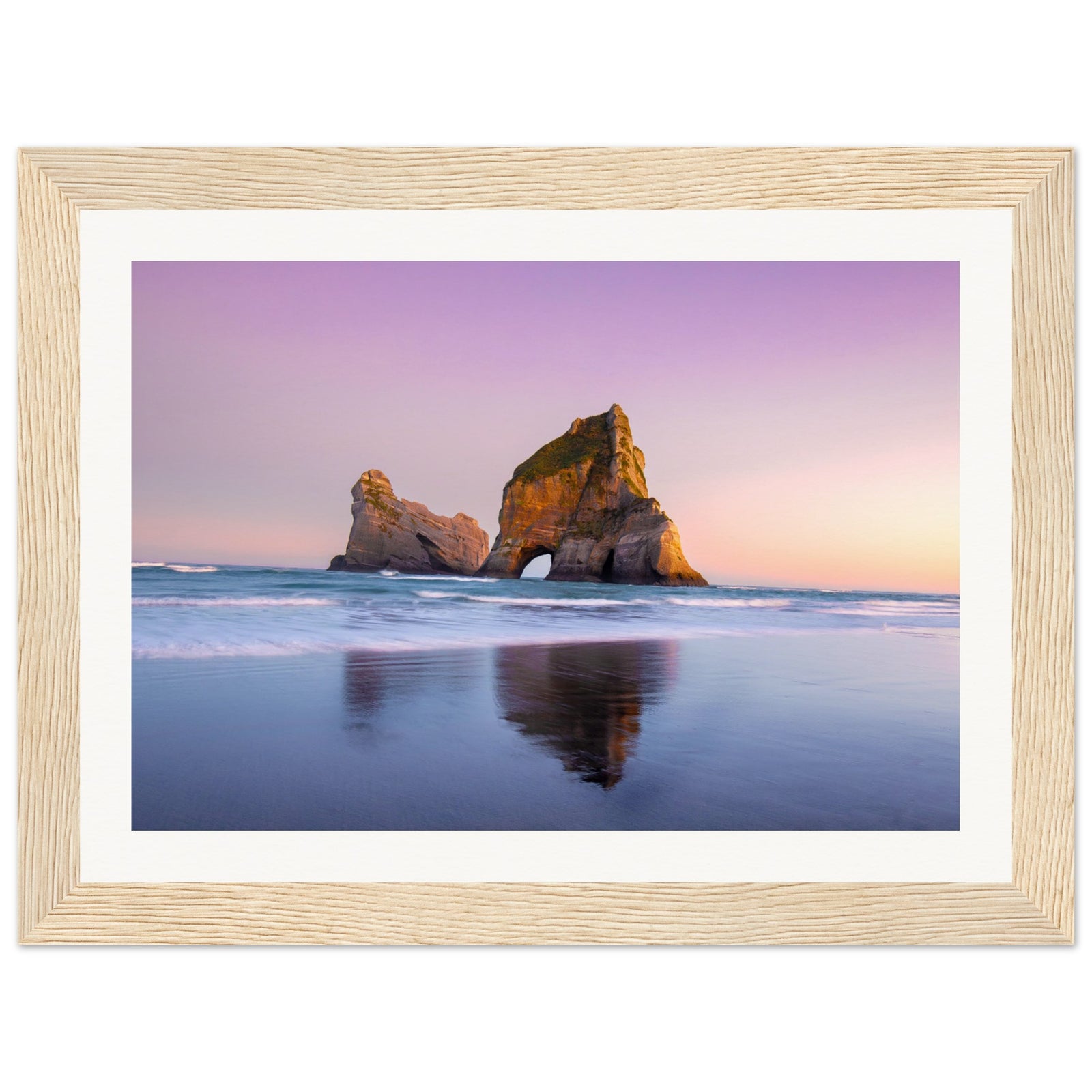 Portrait of ocean tranquility with rock form in pastel sky.

