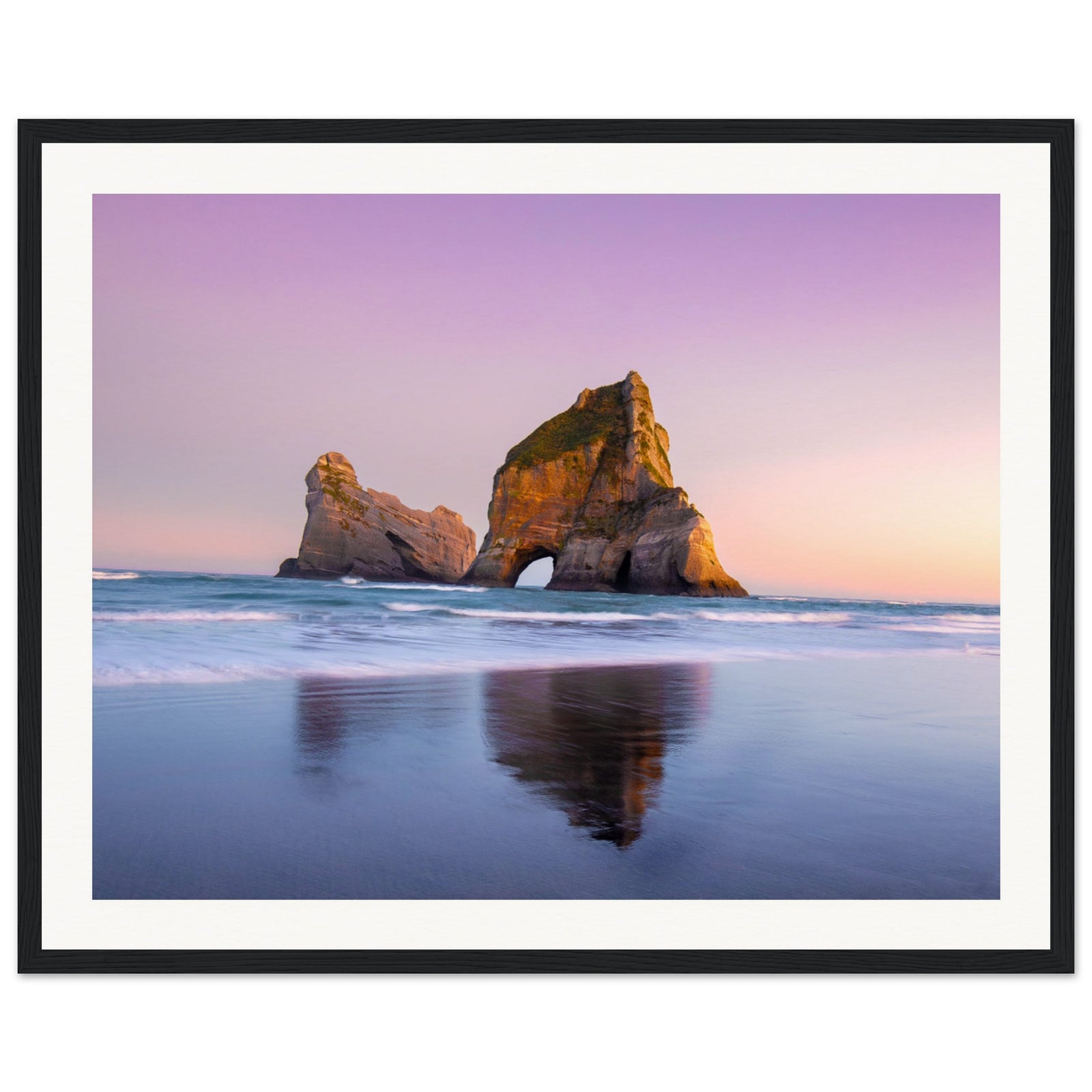 Framed landscape of golden rock arch and purple sea.


