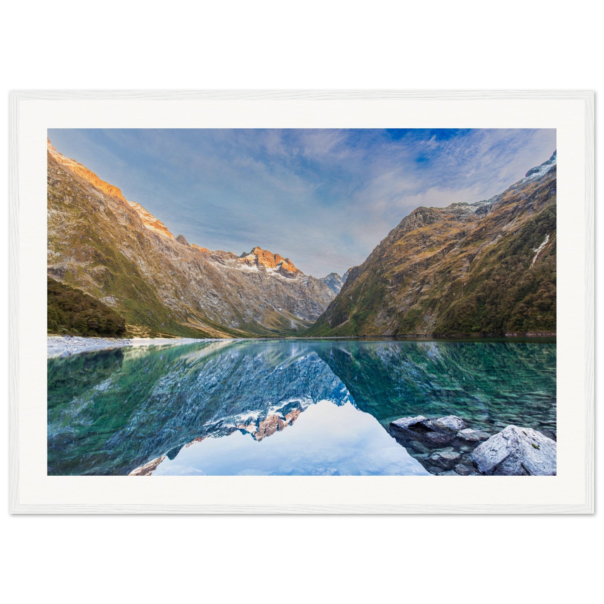 Vertical mountain scene with mirrored water and a marked hillside.

