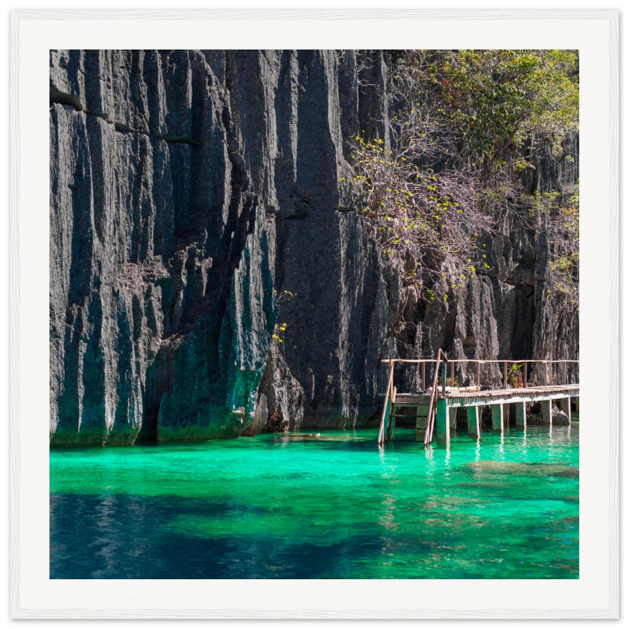 Secluded lagoon with limestone backdrop in a framed display.

