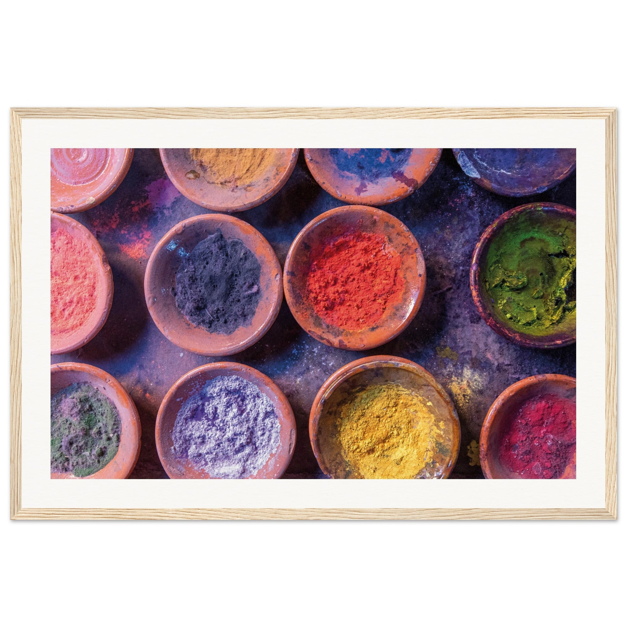 Framed close-up of colorful powders arranged in clay dishes.

