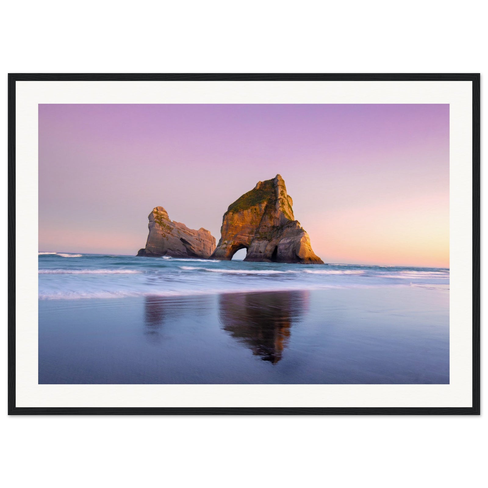 Portrait of sea arch and glowing sky in tranquil moment.


