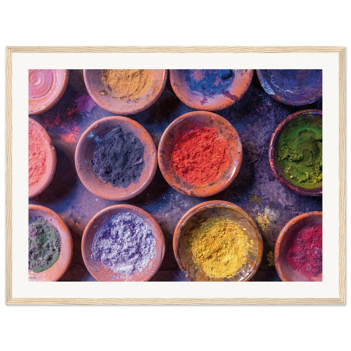 Collection of powdered dyes in terracotta bowls displayed in a frame.

