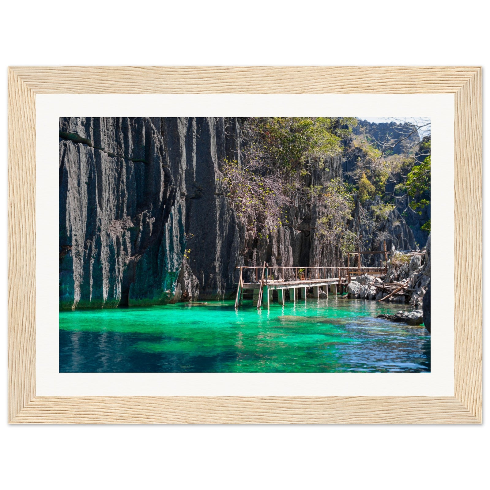 Framed coastal cliff portrait with greenery and wooden structures.

