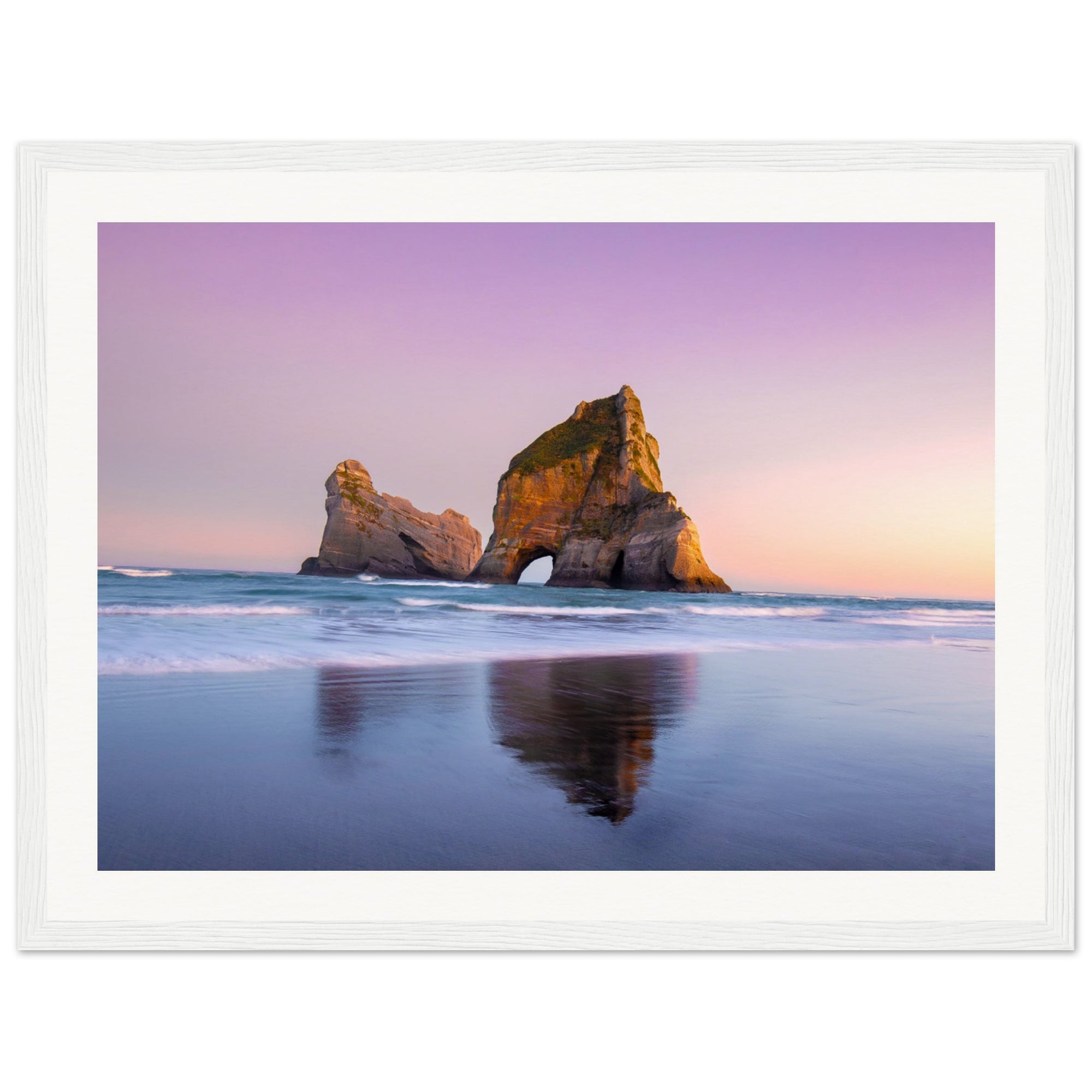 Coastal rock arch at golden hour in portrait view.

