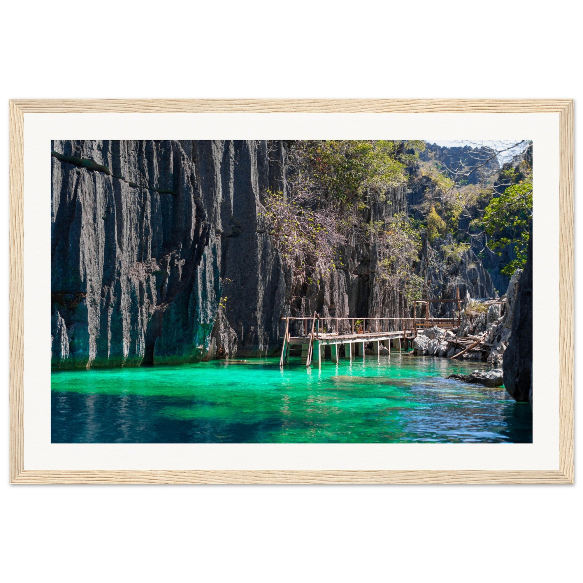 Serene tropical scene with boardwalk, cliffs, and crystal water.

