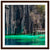 Framed image of jagged stone cliffs meeting calm, green water.

