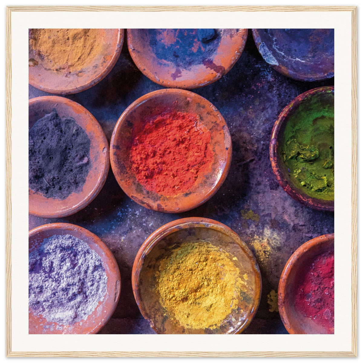 Vivid festival or art powders arranged in a geometric dish layout.

