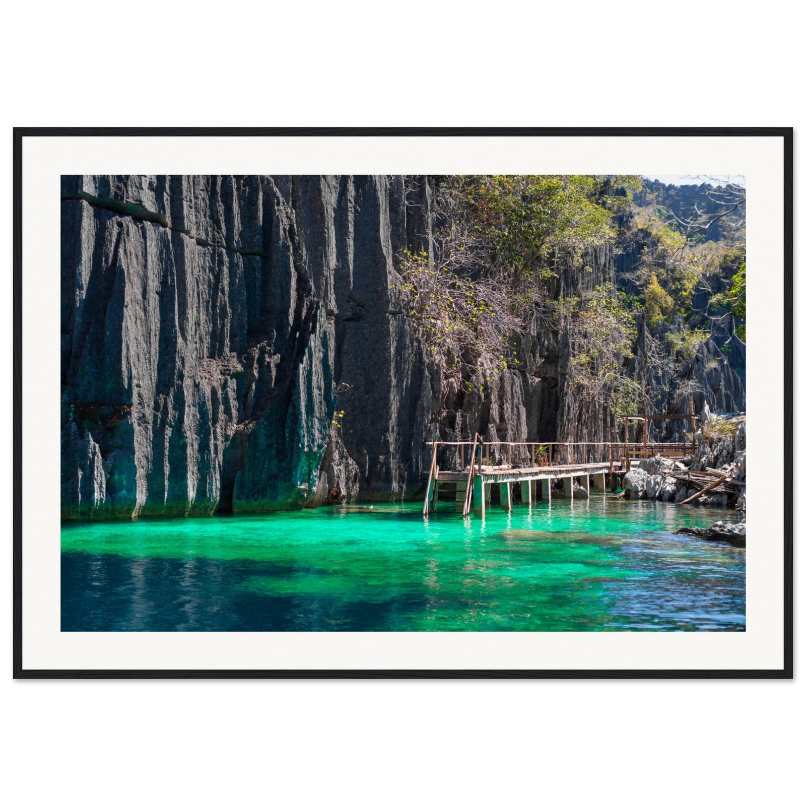 Framed image of dramatic cliffs and glowing sea in a secluded cove.

