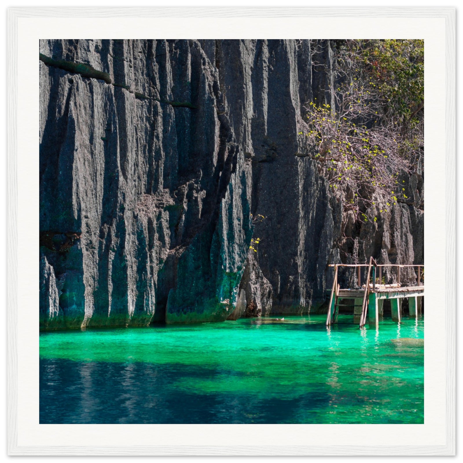Peaceful cliffside cove with shallow teal waters in a wall frame.

