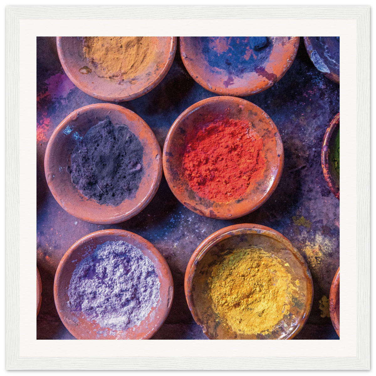 Rustic dishware holding powdered colors in an artistic arrangement.

