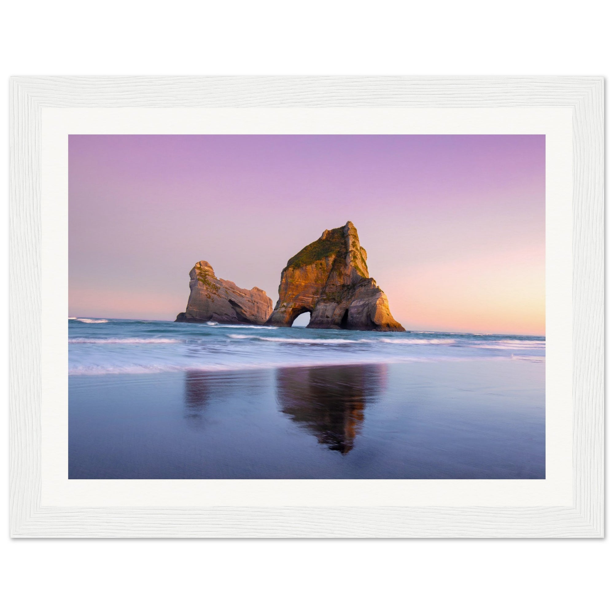 Ocean arch formation glowing in sunset light, framed vertically.

