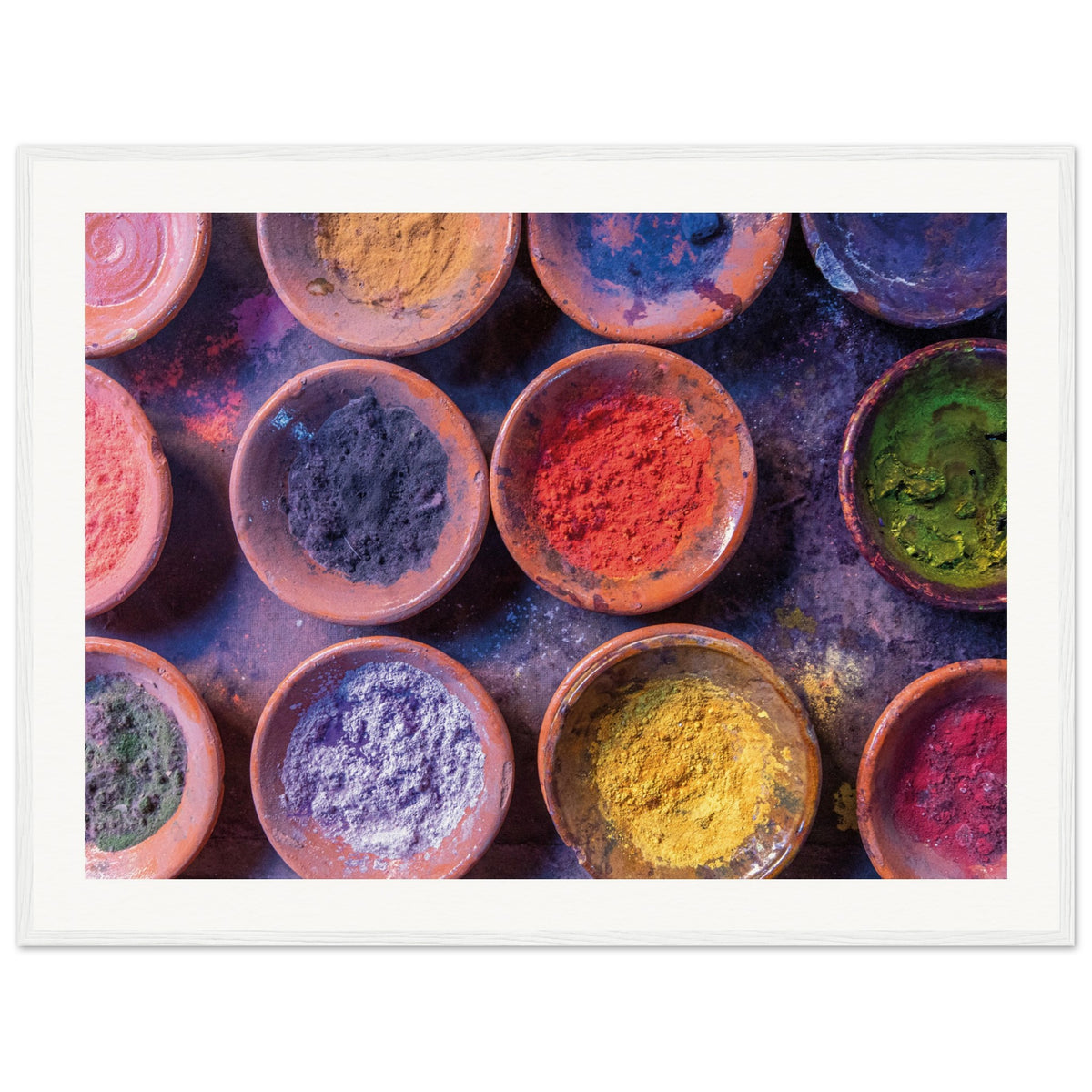 Framed flat lay of multicolored spices or pigments in round dishes.

