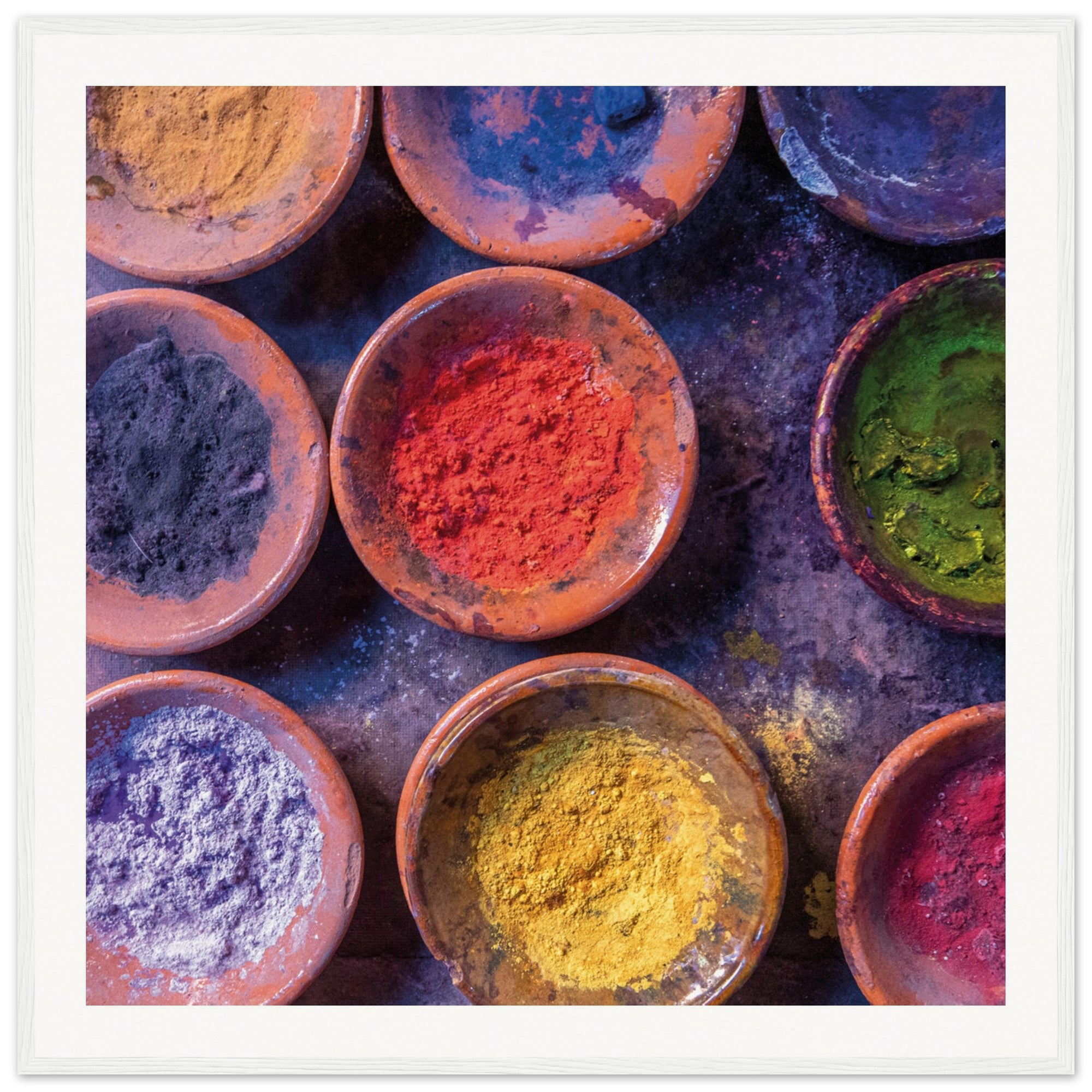 Overhead photo of art pigments in circular bowls with vibrant tones.

