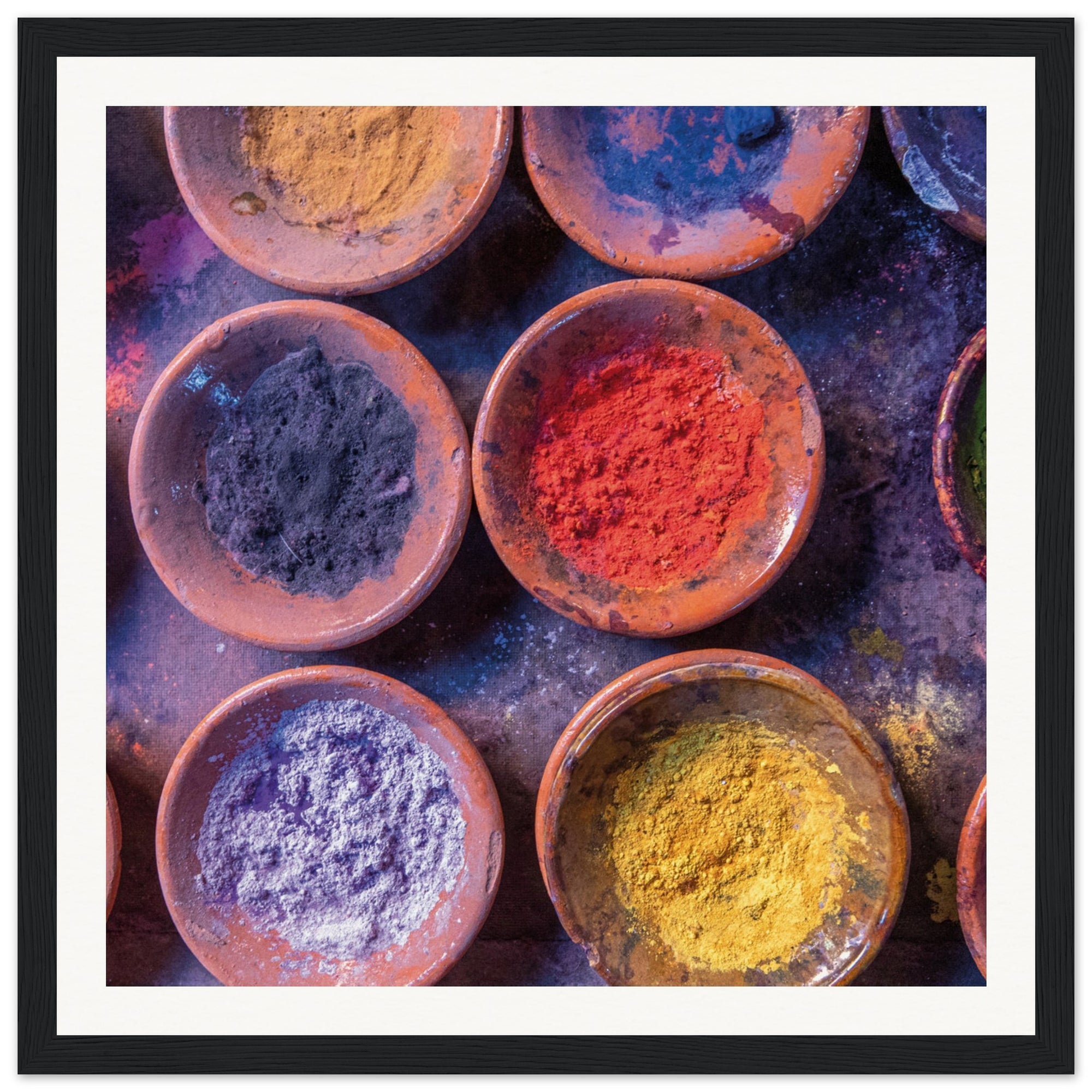 Assorted natural pigments in bowls create a vibrant display.

