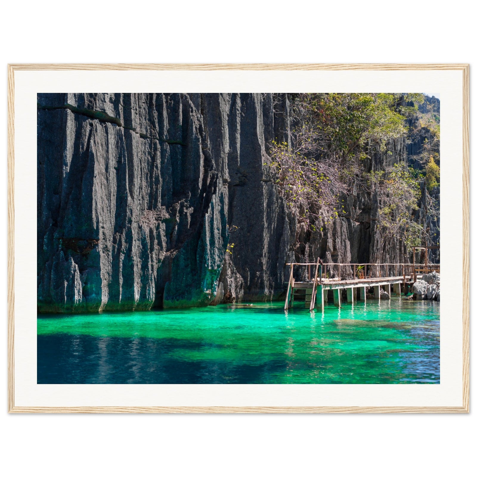 Wooden platform along tropical cliffs captured in a framed seascape.

