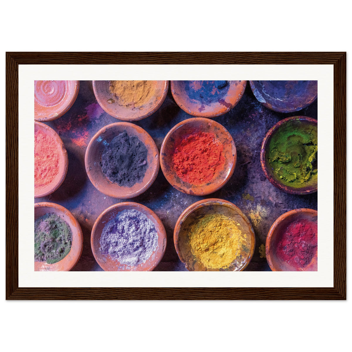 Artistic display of powdered pigments arranged in clay bowls.

