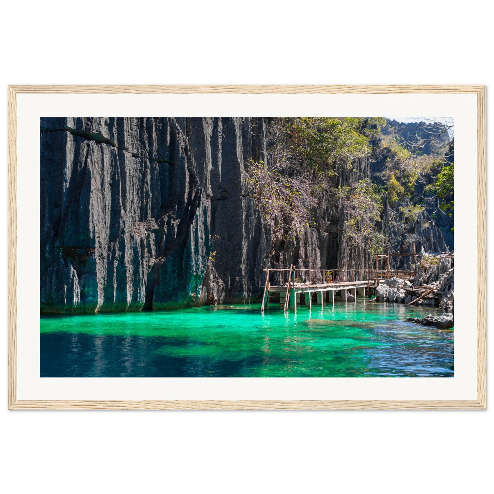 Framed landscape of teal lagoon bordered by towering rock walls.

