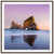 Natural sea arch mirrored in shoreline under pastel sky.


