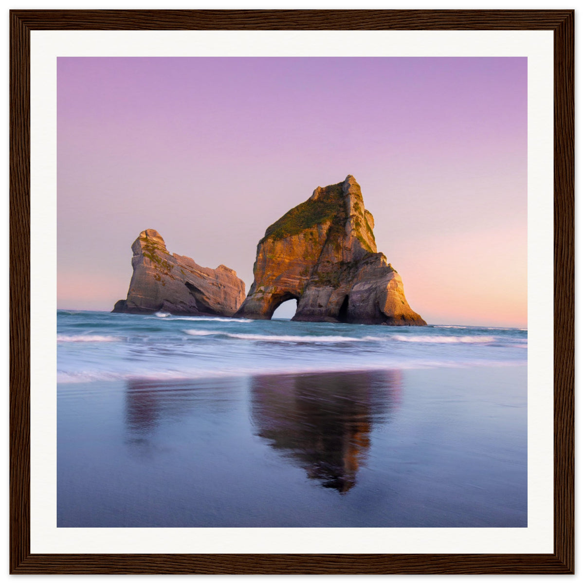 Soft sky tones over striking sea arch captured in a frame.


