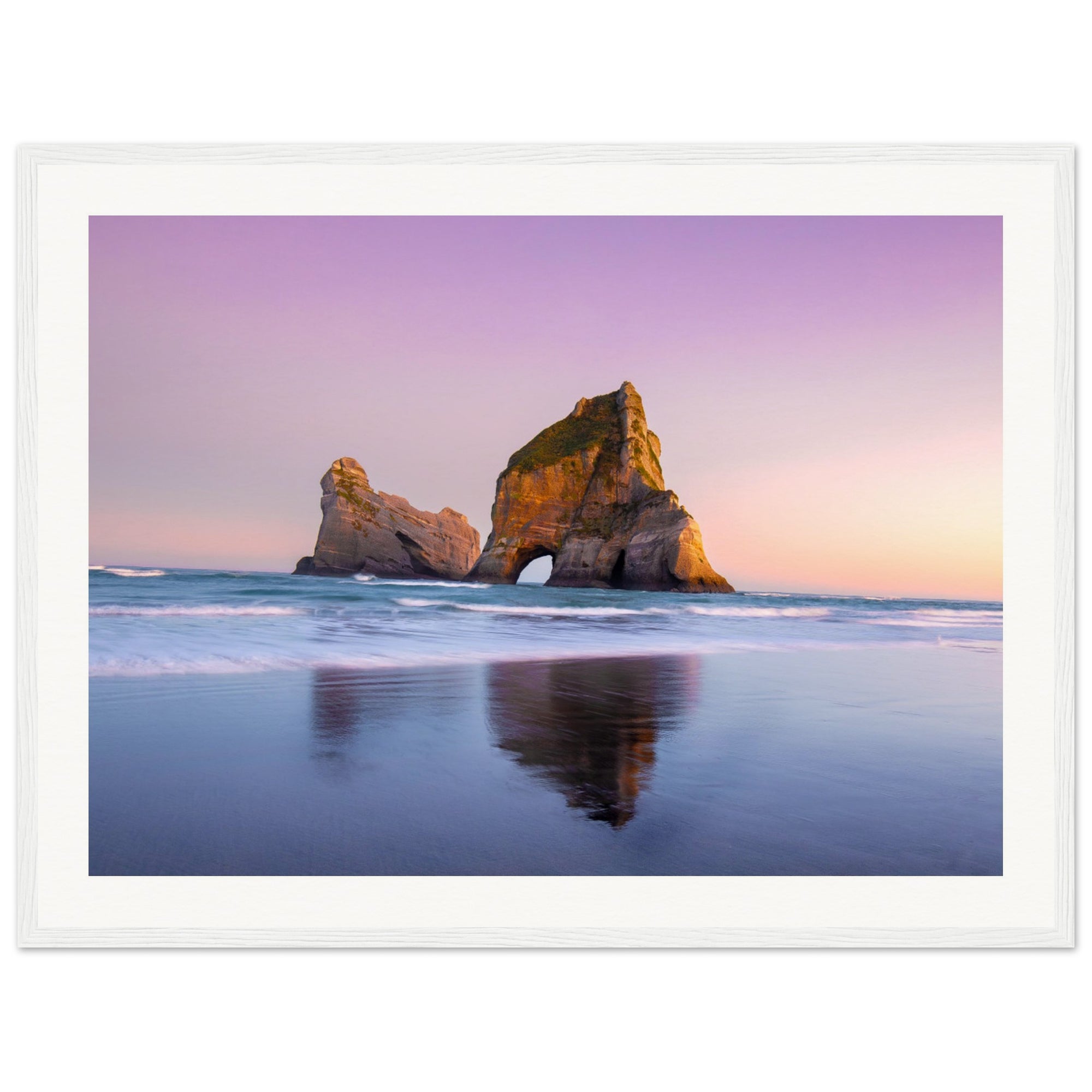 Peaceful shoreline with sea arch and lavender sky in portrait view.

