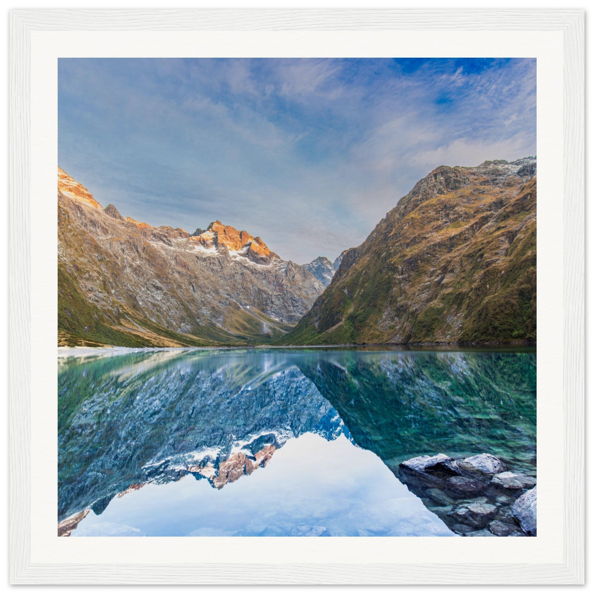 Mountain lake portrait with a glowing ridge and reflection.


