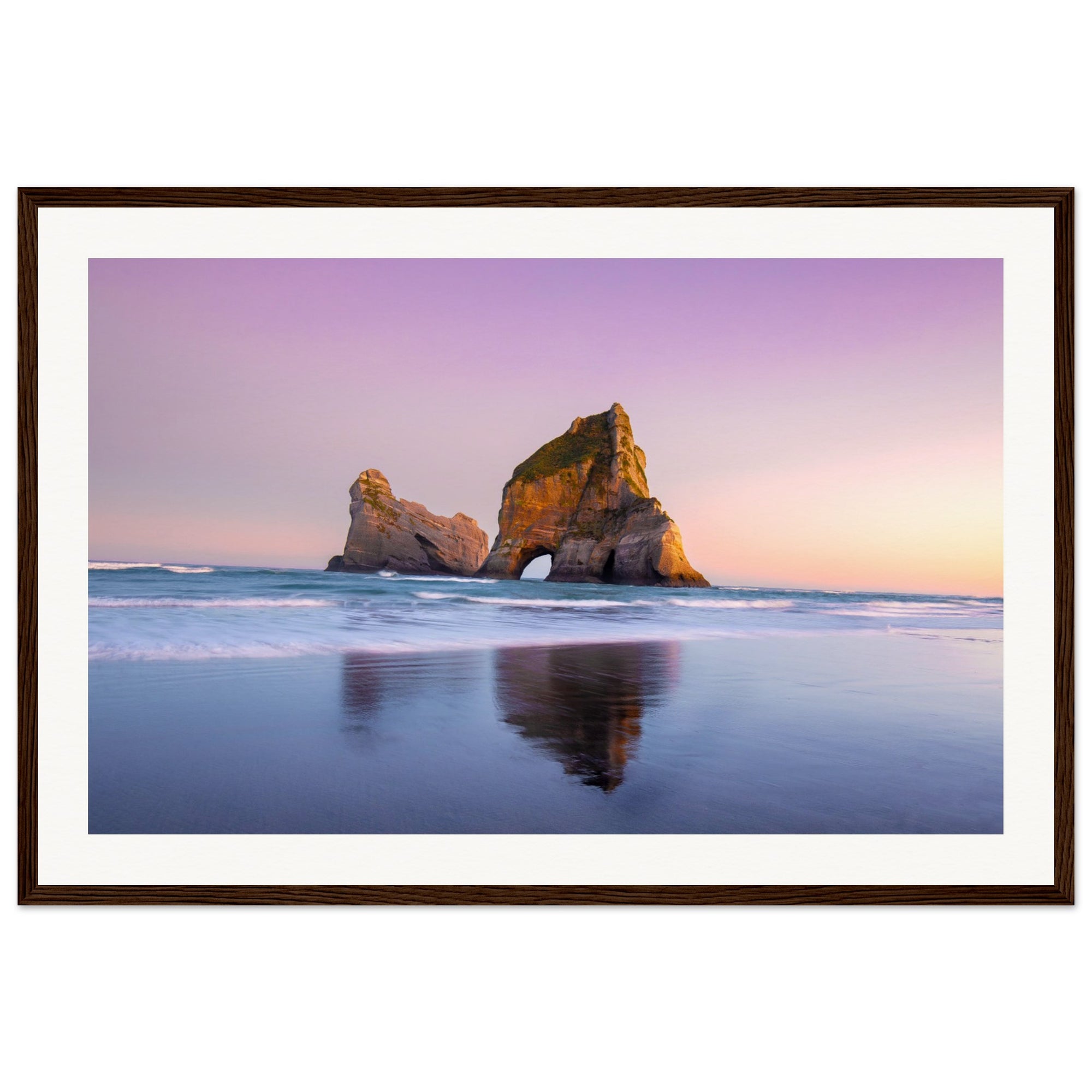 Minimalist ocean view with pink sky and rock in frame.

