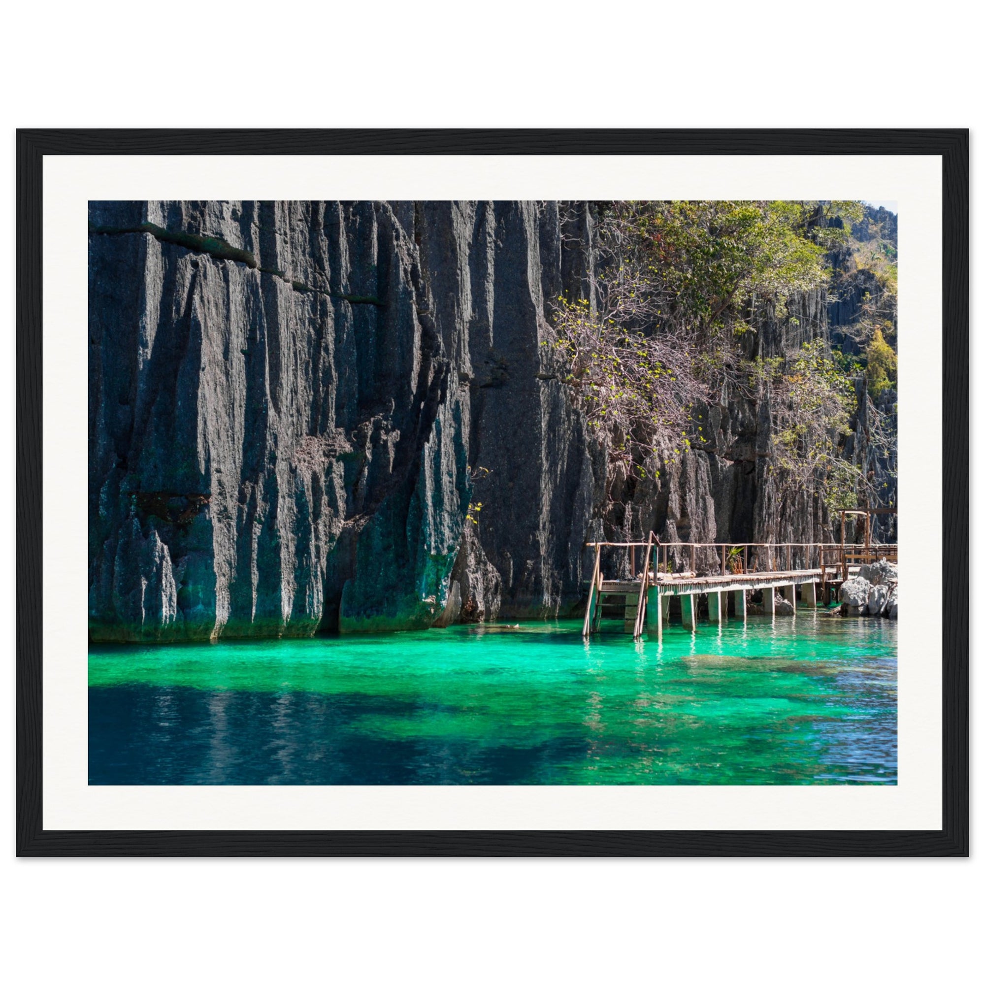 Calm lagoon framed by vertical cliffs and soft green light below.

