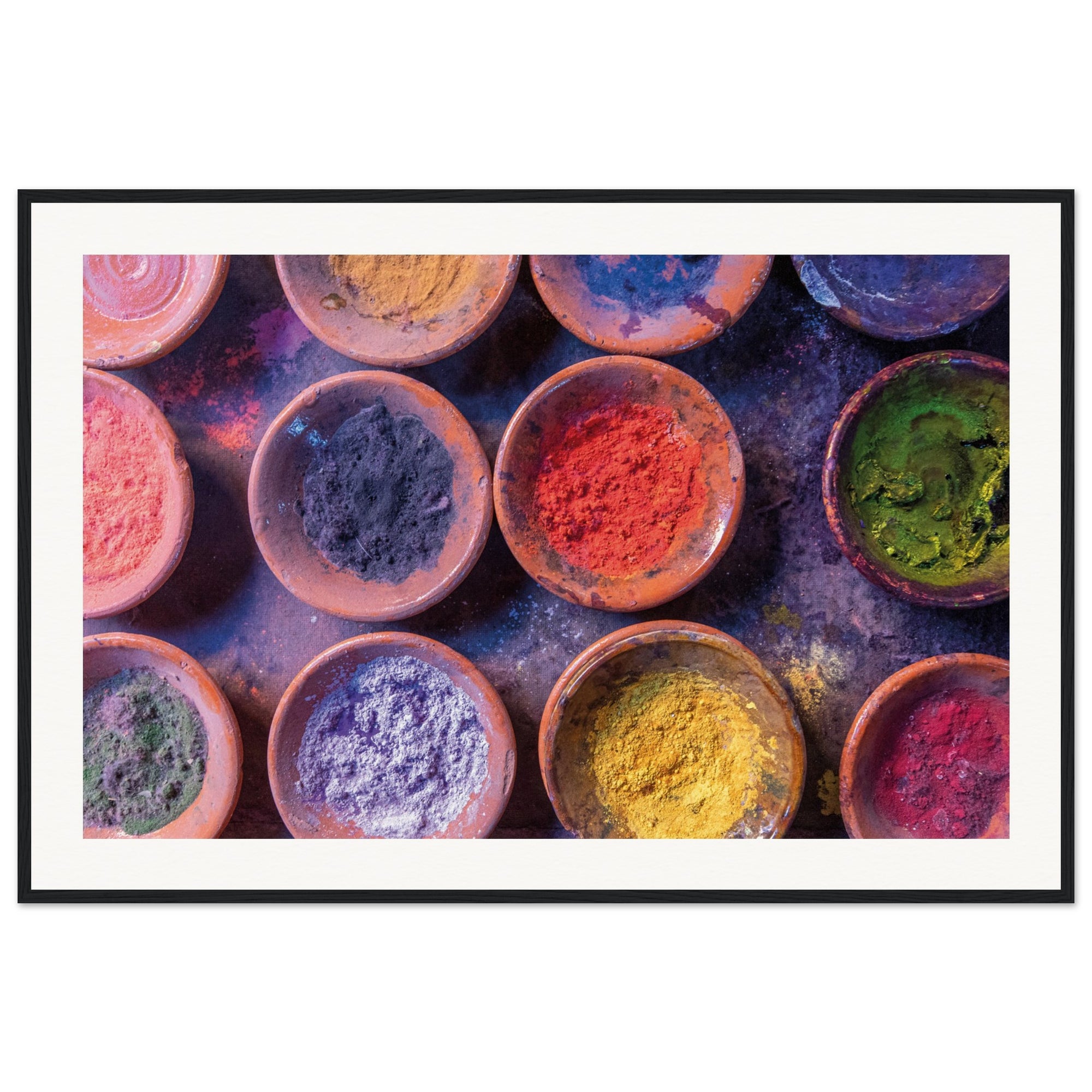 Symmetrical bowl pattern filled with vibrant powders in a framed view.

