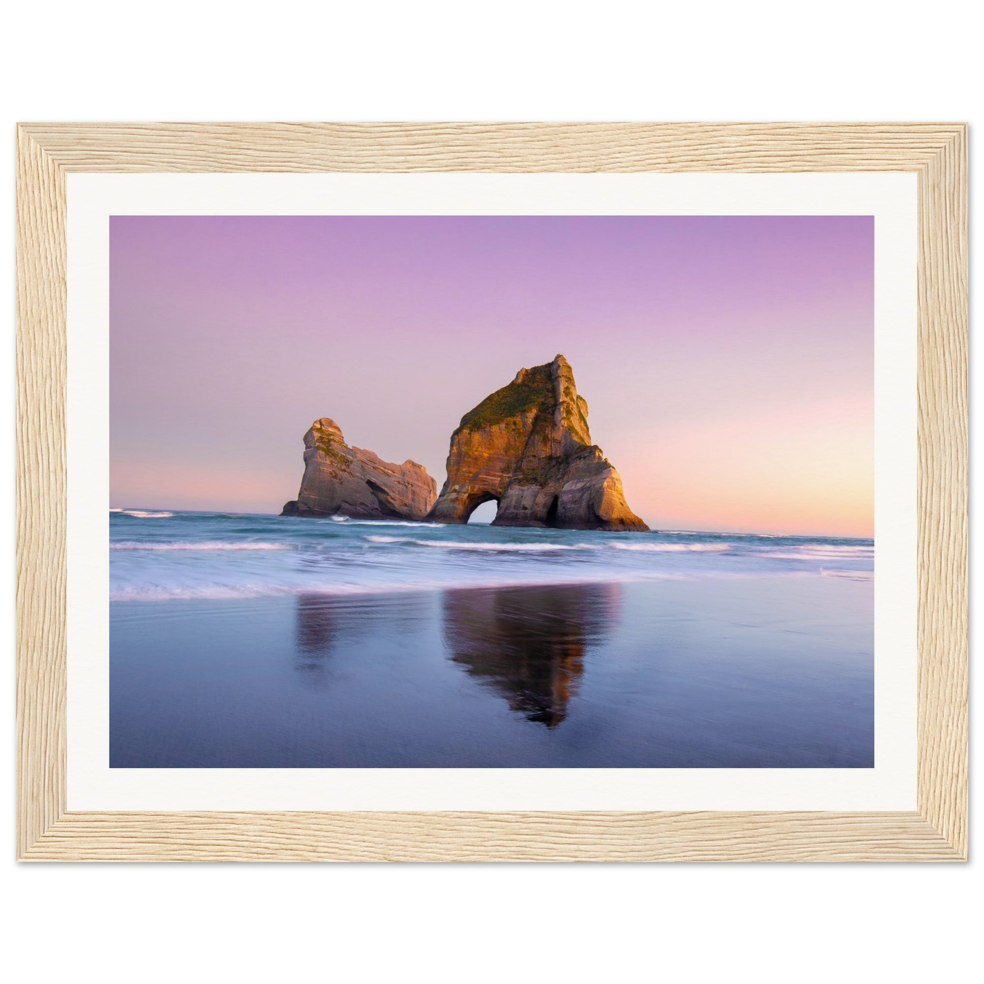 Soft ocean colors surrounding rugged rock in framed photo.

