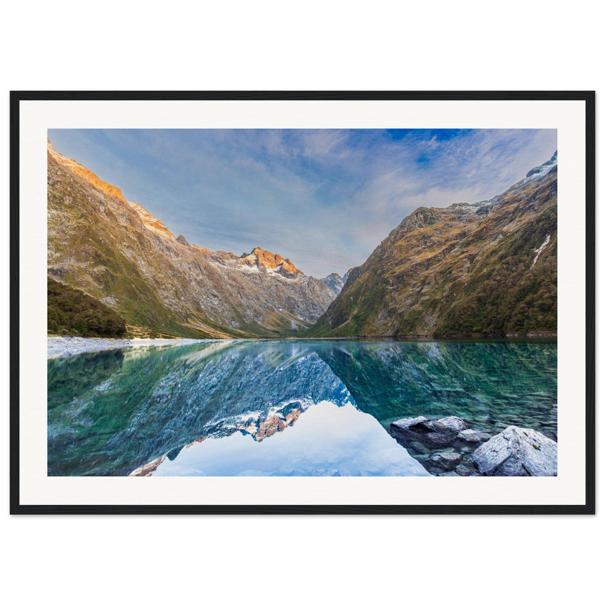 Landscape portrait featuring crystal lake and sunlit mountain.

