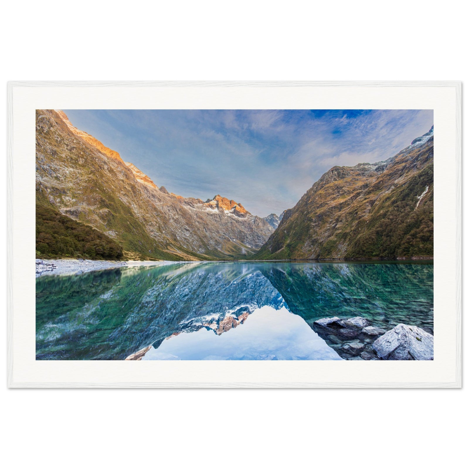Portrait of a serene alpine lake with reflections and a marked ridge.

