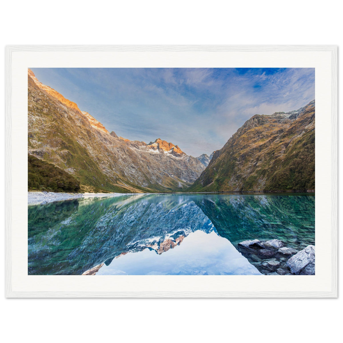 Framed print of scenic landscape with dot on left-side mountain.

